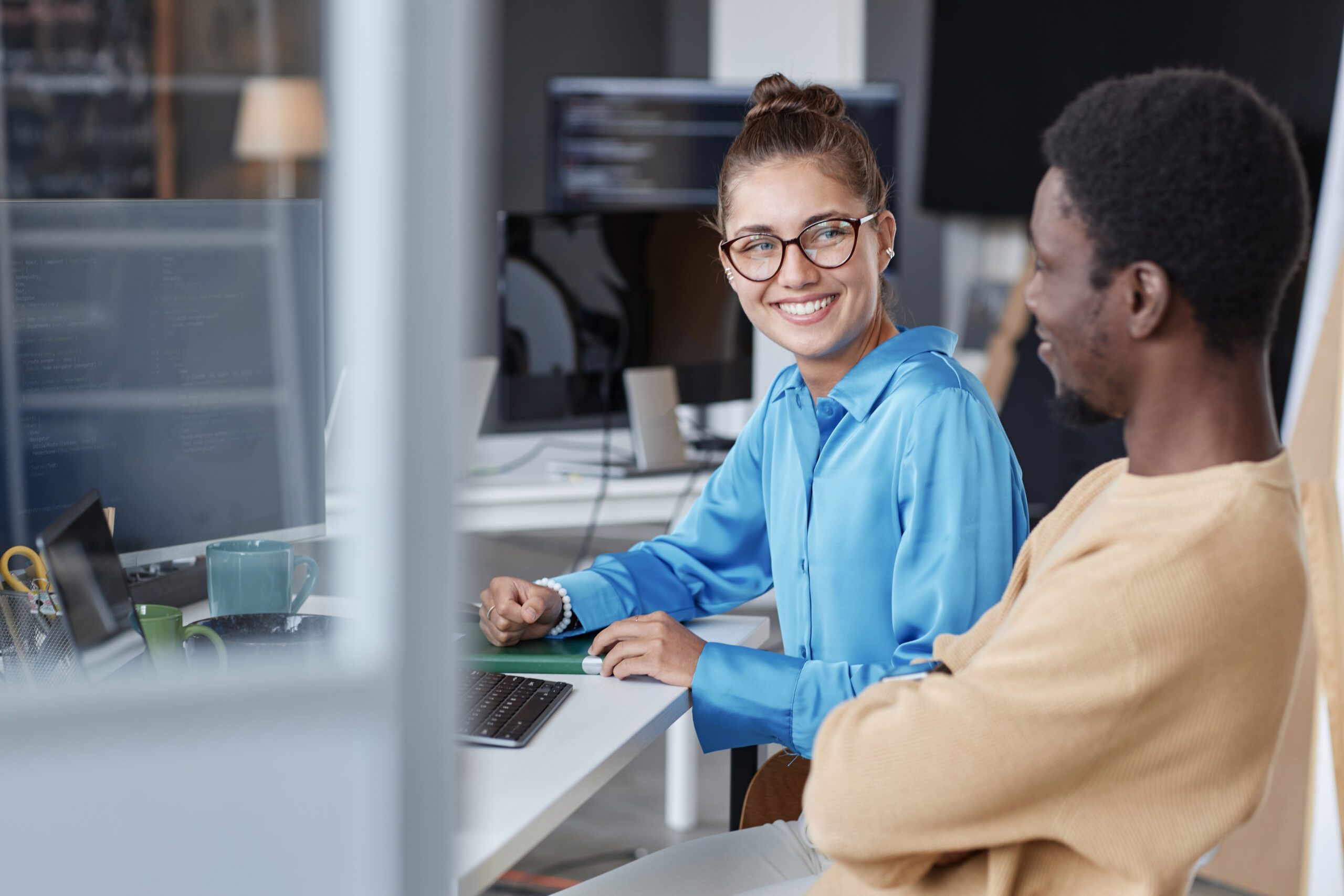 Ein paar junge Programmierer arbeiten mit Software am Computer im Team im IT-Büro.