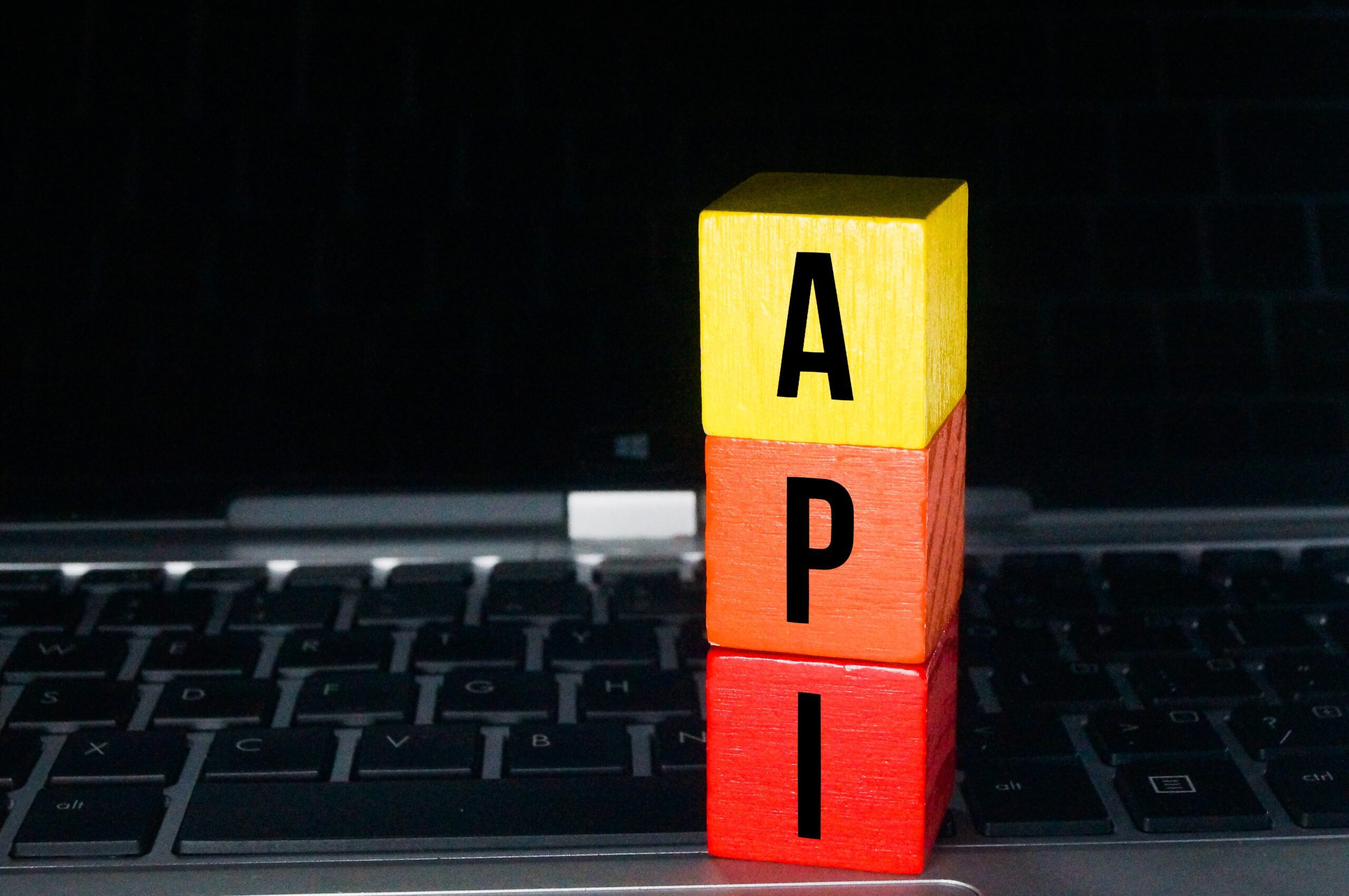 Rote, orange und gelbe Würfel sowie die Buchstaben API oder APP.