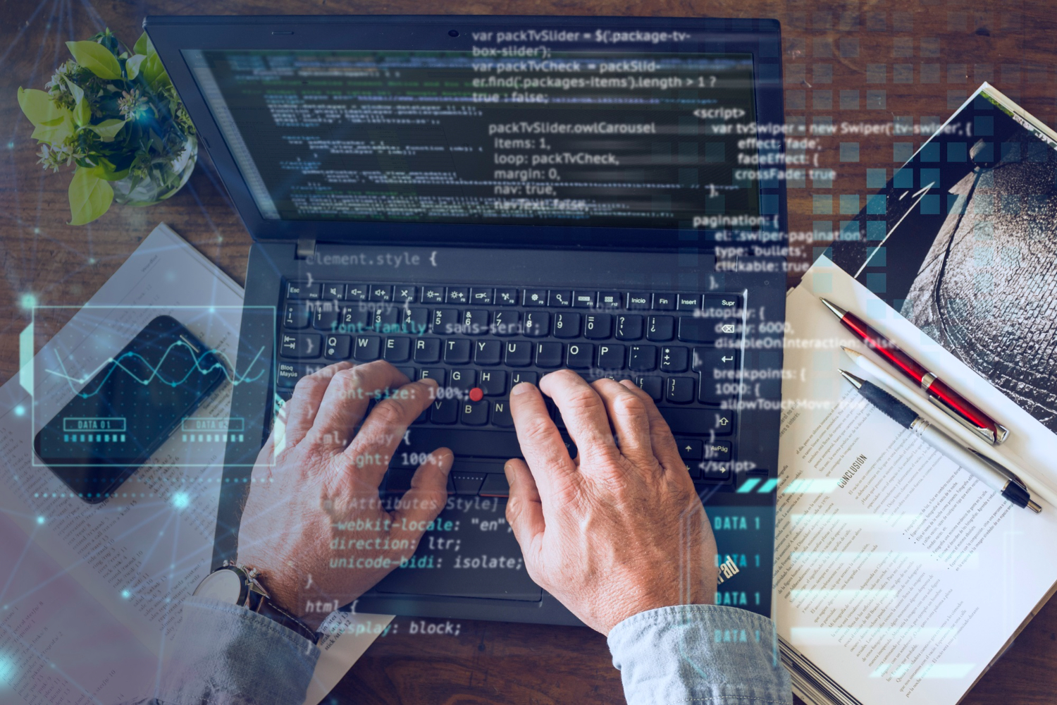 Ein Mann, der am Computer codiert, mit Dokumenten auf dem Desktop.