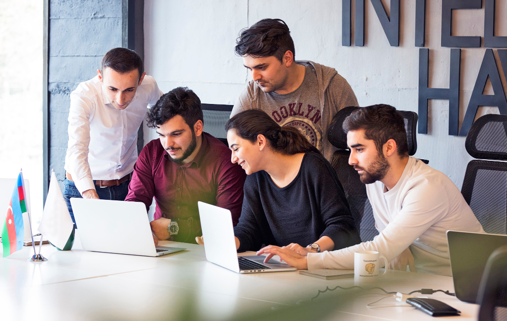 Eine Gruppe von Büroangestellten, die auf einen Computerbildschirm schauen, konzentriert und produktiv.