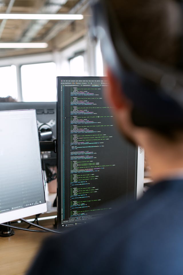 Ein Mitarbeiter, der Code entwickelt, konzentriert und kreativ in einer technologischen Arbeitsumgebung.