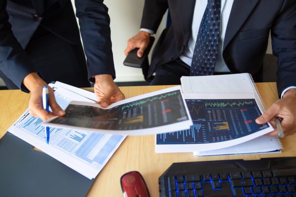 Investor and trader discussing statistic data Büroangestellte, die Finanzgrafiken verwenden.